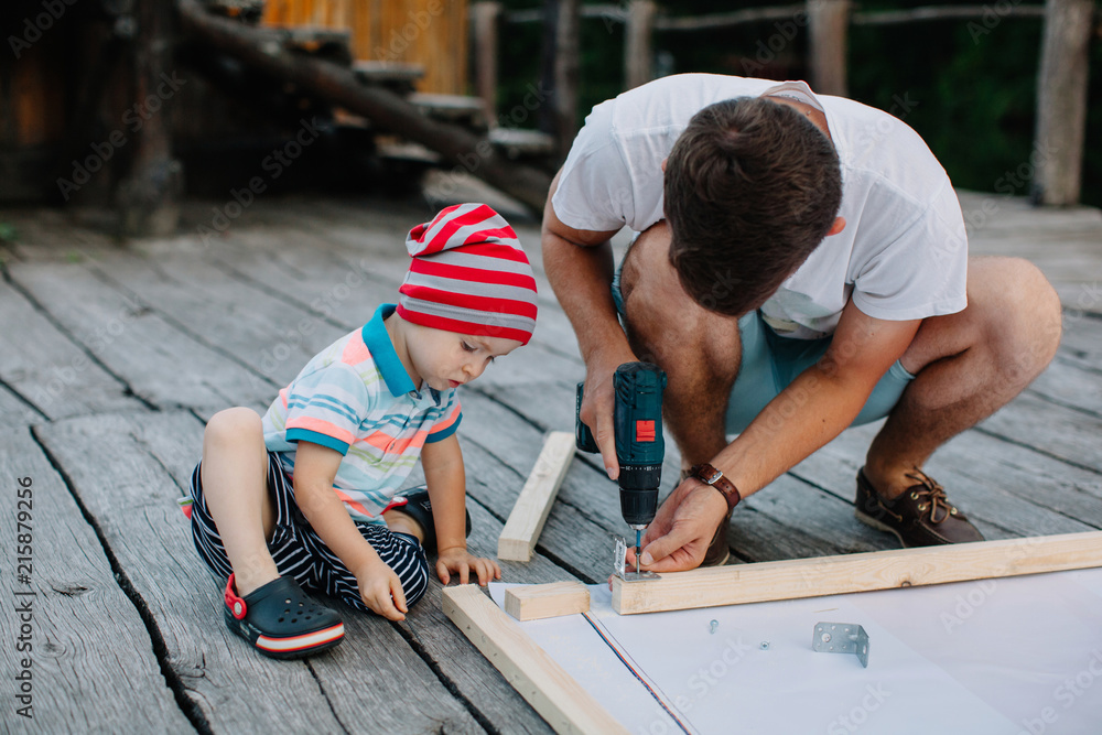 Man and son busy with carpentry Man and son busy with carpentry