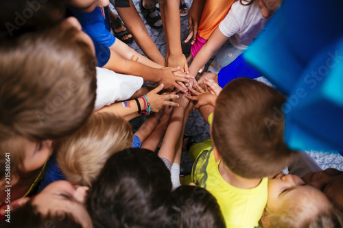 Fototapeta Naklejka Na Ścianę i Meble -  Community of children holding hands together closeup in the Kindergarten