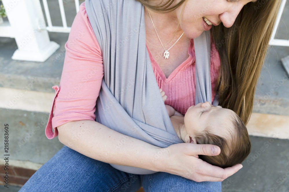 Baby wearing mother cups head of infant in her hand Baby wearing mother cups head of infant in her hand