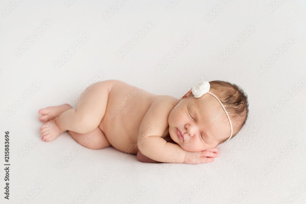 Sleeping newborn girl on a white background. Photoshoot for the newborn. 7 days from birth. A portrait of a beautiful, seven day old, newborn baby girl	 - obrazy, fototapety, plakaty 