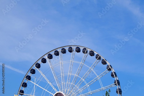 ferris wheel giant top half blue sky soft clouds