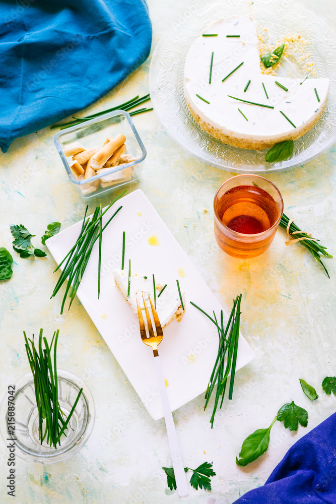 Salty cheesecake with chives, made with cheese and greek yogurt, chives, shot   on a green board, top view