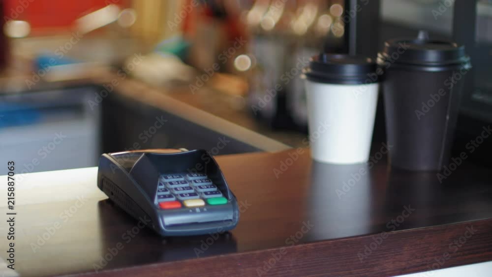 Business woman in cafe is paying the price by using a smart watches and terminal Business woman in cafe is paying the price by using a smart watches and terminal