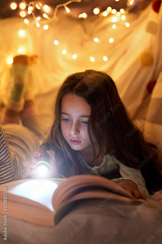 Young girl reading with flashlight Young girl reading with flashlight