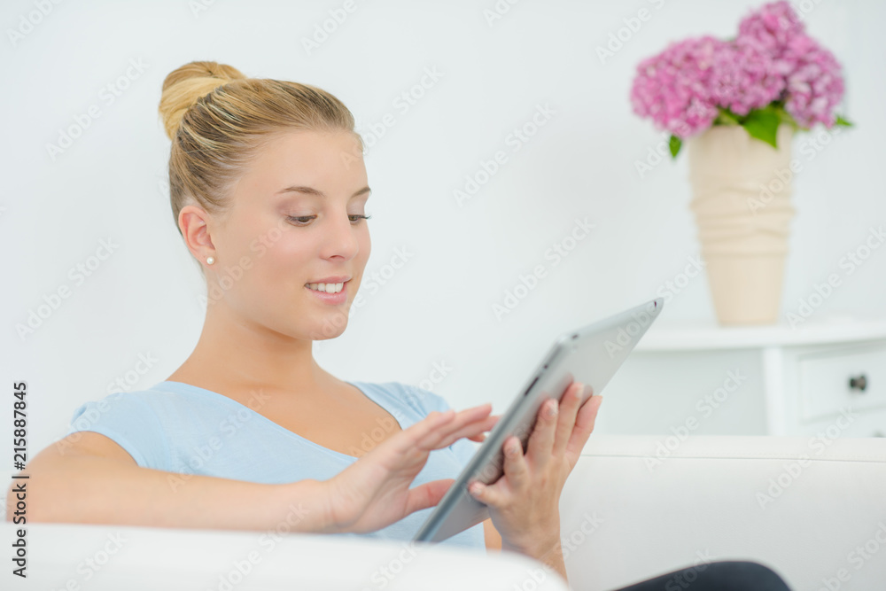 Woman using her tablet computer as she waits for an appointment Woman using her tablet computer as she waits for an appointment