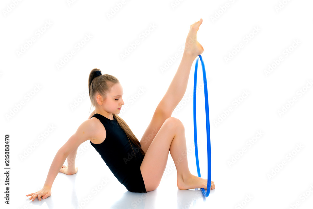 A girl gymnast performs an exercise with a hoop. A girl gymnast performs an exercise with a hoop.