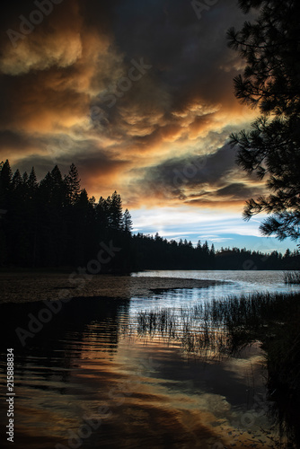 Smoke over California forest and lake at sunset