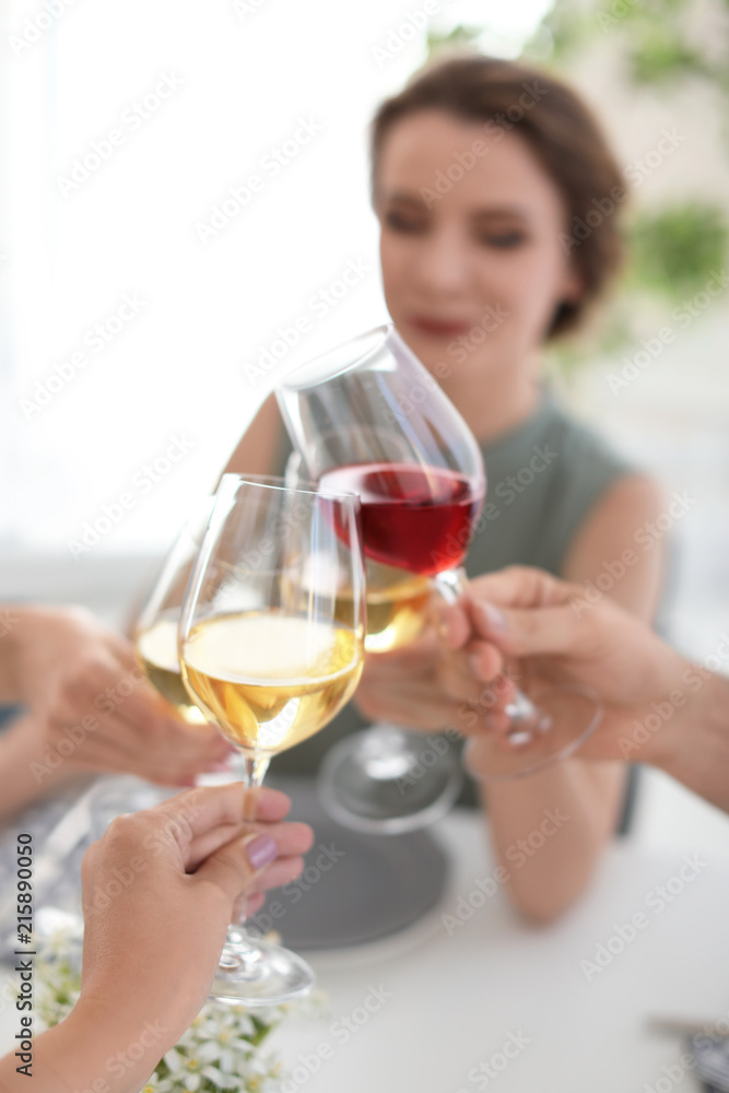Young people with glasses of delicious wine at table