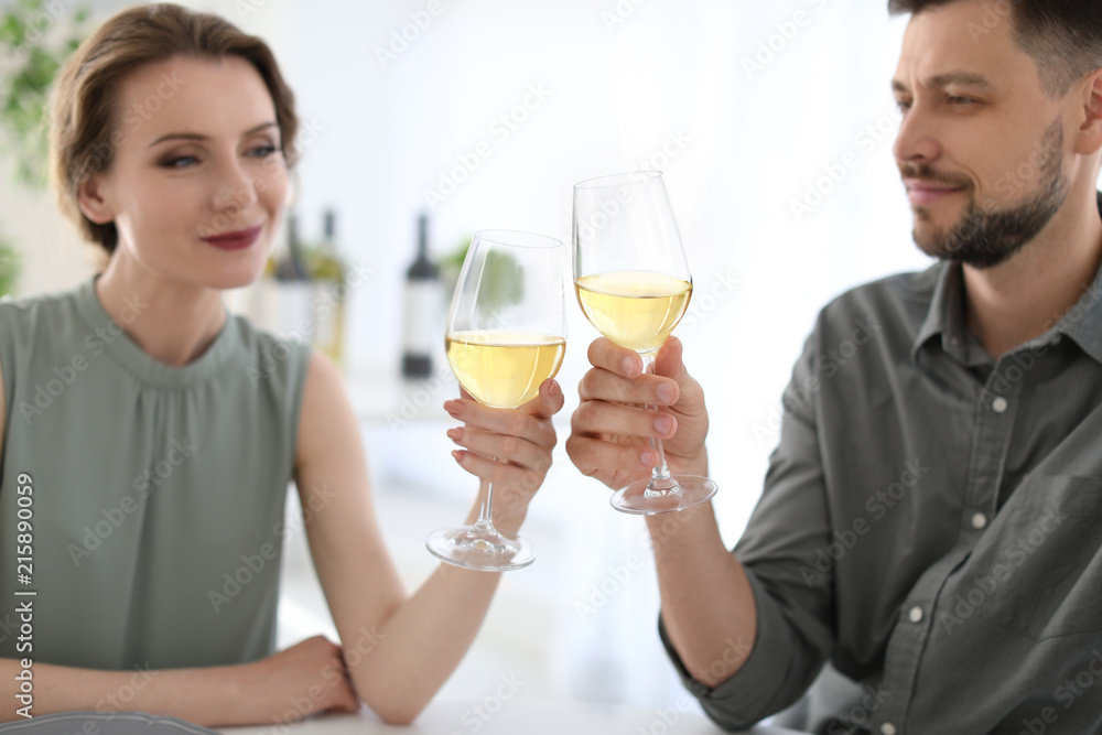 Young couple with glasses of delicious wine indoors Young couple with glasses of delicious wine indoors