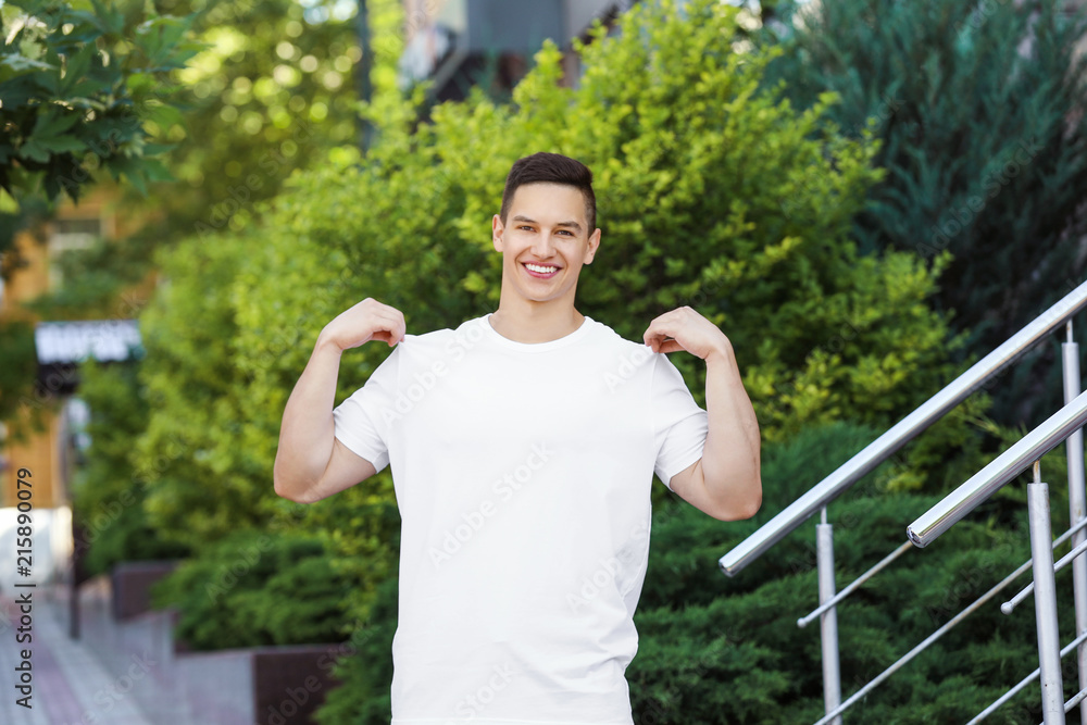 Young man in white t-shirt outdoors. Mockup for design Young man in white t-shirt outdoors. Mockup for design