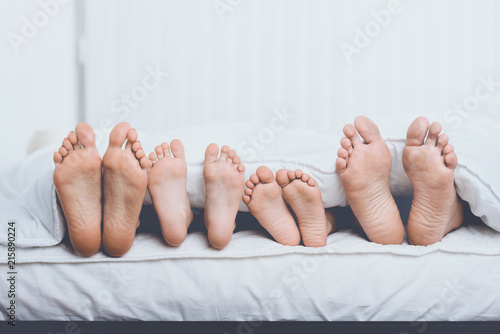 Close up Family in Bed under Cover Showing Feet photo