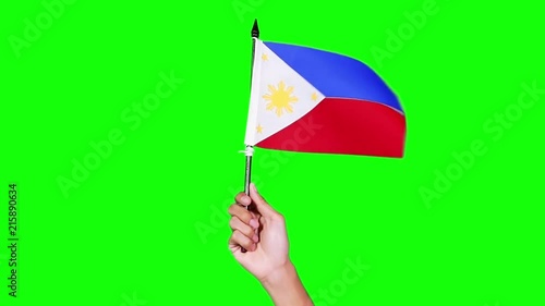 Slow motion of hand holding Philippine country flag on green screen background in the studio photo