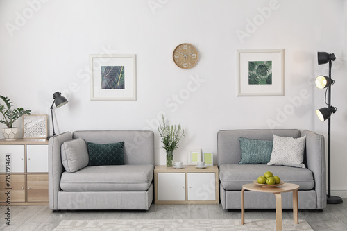 Modern interior of living room with comfortable armchairs near white wall © New Africa
