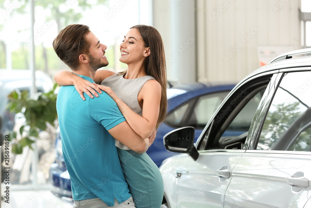 Happy couple buying new car in salon Happy couple buying new car in salon