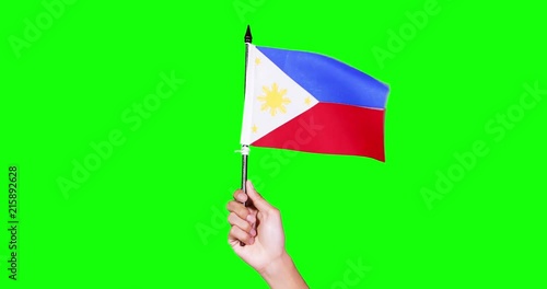 Hand holding a national flag of Philippine country on green screen background in the studio. Shot in 4k resolution photo