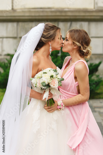 Bride and bridesmaid kissing at wedding day. Happy marriage and wedding  party concept Stock Photo | Adobe Stock