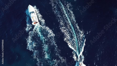 View from above, aerial view of a yacht sailing on a transparent and turquoise sea. Emerald Coast, Sardinia, Italy.