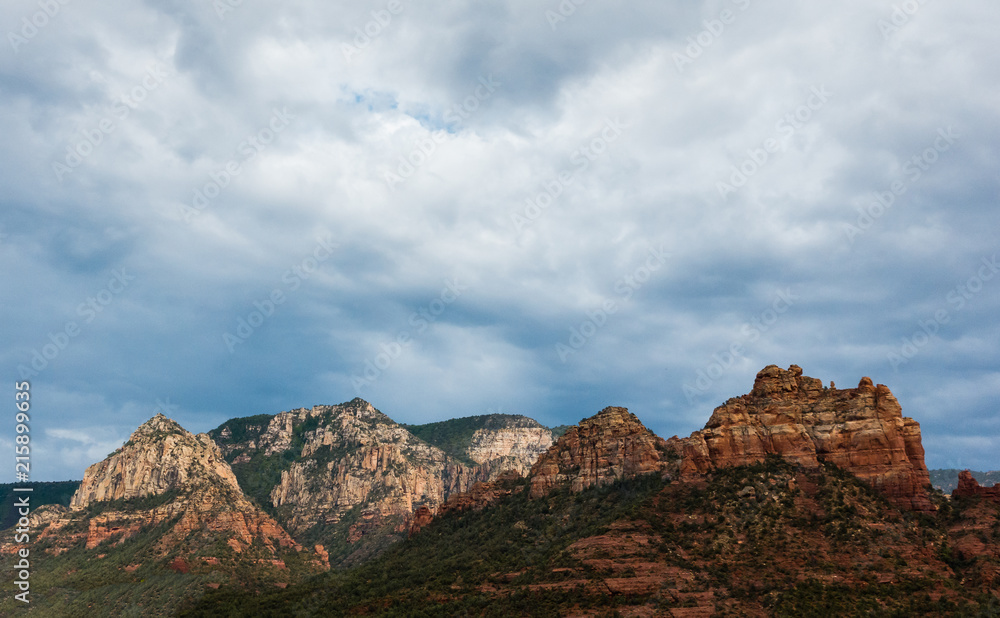 Stunning Sedona, Arizona mountain landscape with dramatic monsoon sky and sun glow