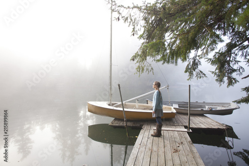 Twelve year old girl stands on a dock on a foggy morning on Fletcher Bay photo