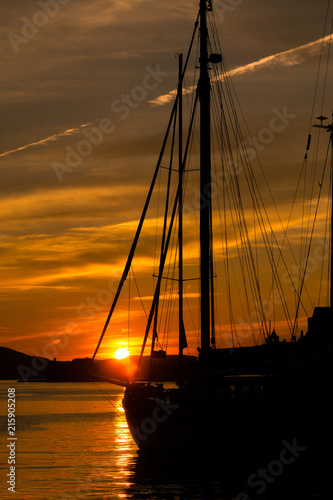 Fototapeta Naklejka Na Ścianę i Meble -  Sailboat against the backdrop of a glowing sunset