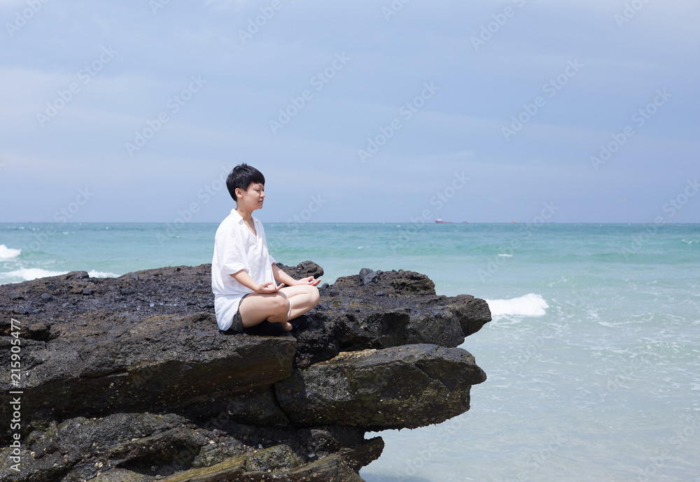 Yoga meditation of Asian women, in the beautiful seaside natural rock Yoga meditation of Asian women, in the beautiful seaside natural rock