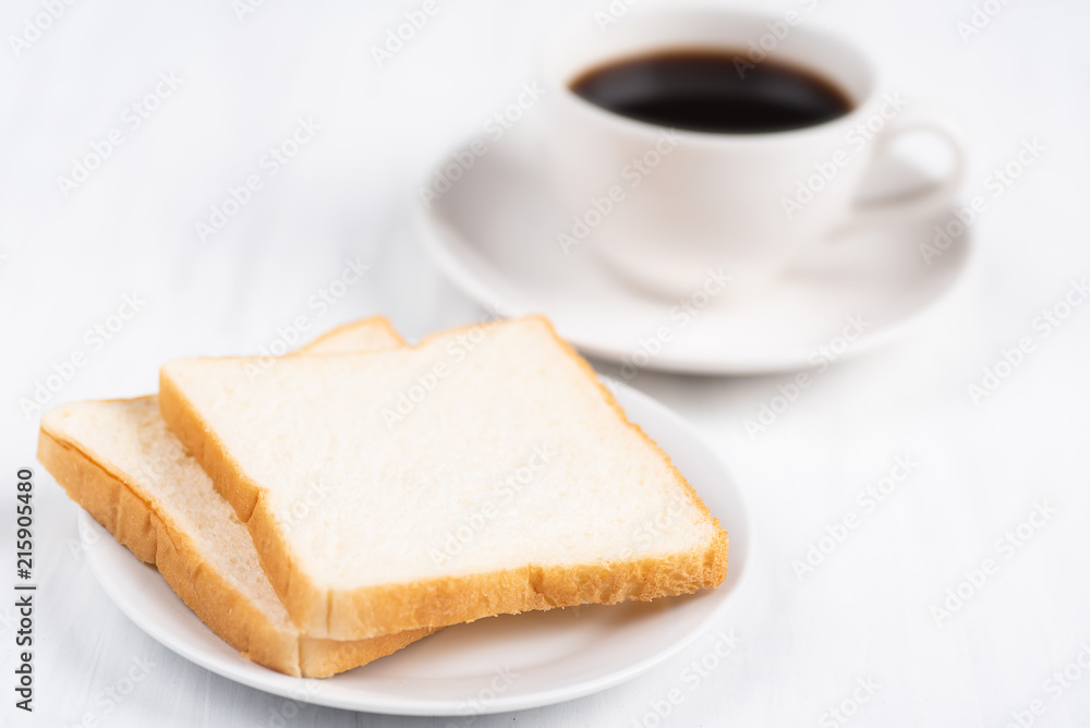 Sliced bread and cup of black coffee on white table, breakfast Sliced bread and cup of black coffee on white table, breakfast