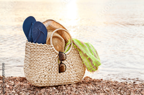 Straw Bag, Hat, Sunglasses And Flip Flops On The Shore In The Summer