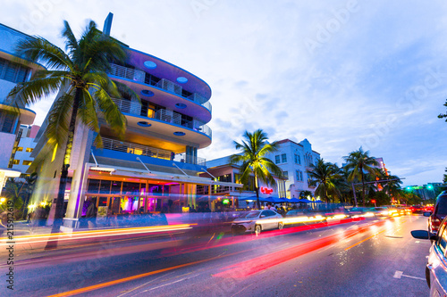 Ocean Drive scene at sunset with lights, palm trees, cars and people having fun, Miami beach. Art Deco style hotels and restaurants at sunset on Ocean Drive, world famous destination for its nightlife photo