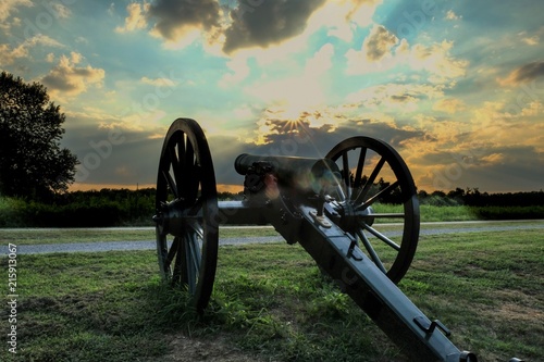 an old Civil War cannon points towards the sunset at Stones River National Battlefield in Murfreesbore Tennessee