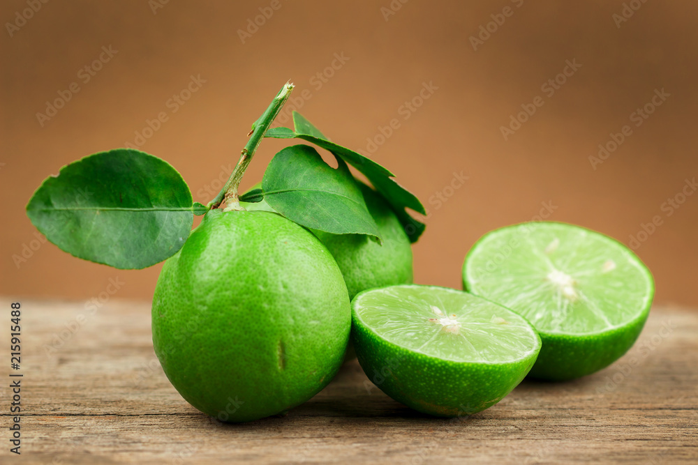 Fresh limes on wooden table over brown background Fresh limes on wooden table over brown background