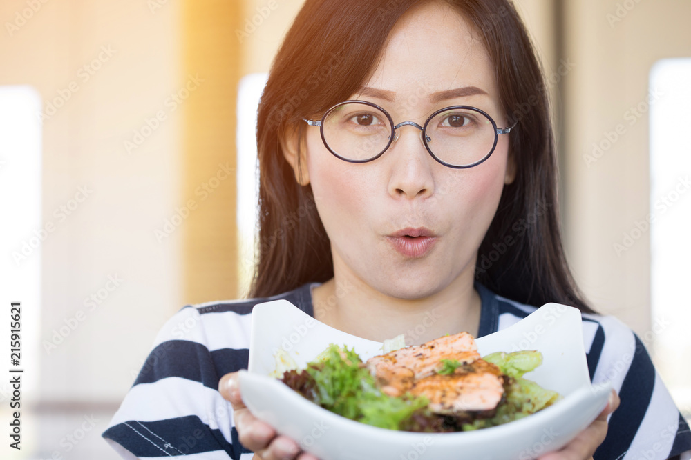 Healthy lifestyle asian woman showing salad smiling.