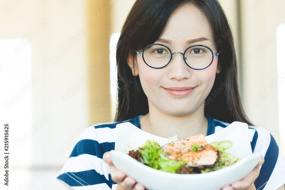 Healthy lifestyle asian woman showing salad smiling.