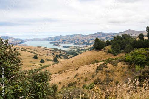 View across rolling hills to the natural harbour of Akaroa, New Zealand