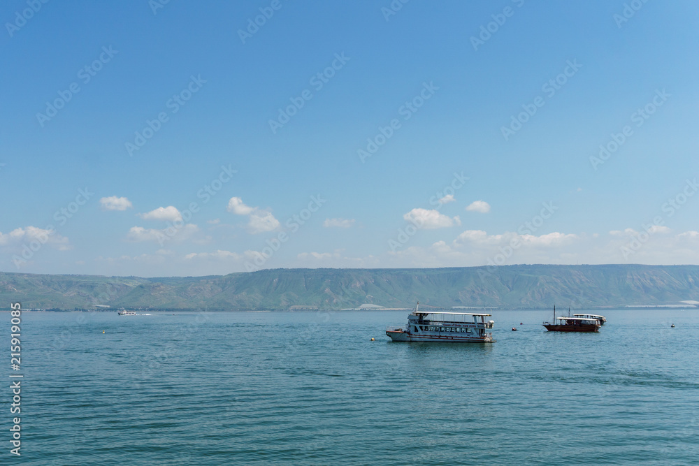 Old boat on Sea of Galilee in Israel at foggy spring day.
