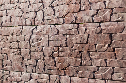 Stone brown fence close-up. Photographed in daylight.