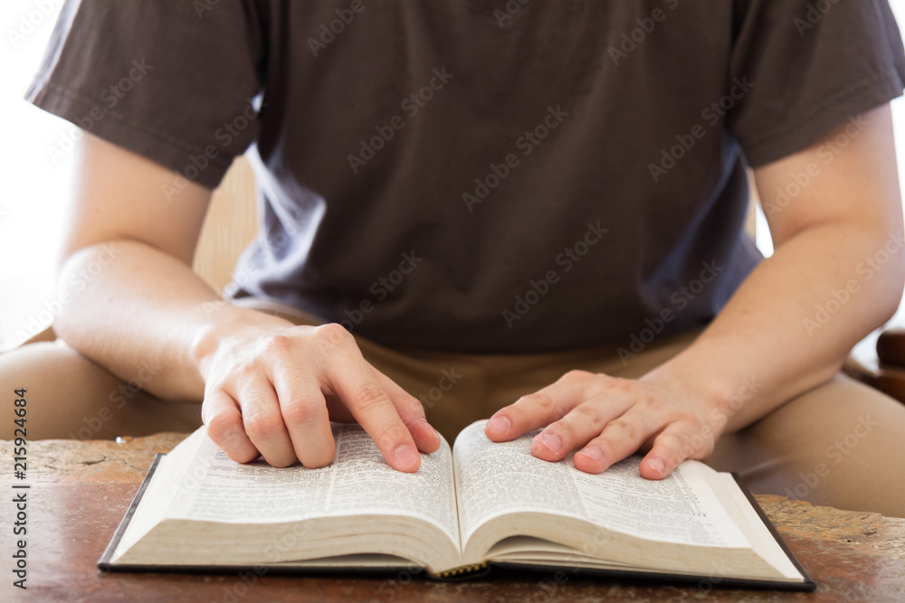 man sitting on sofa and reading book