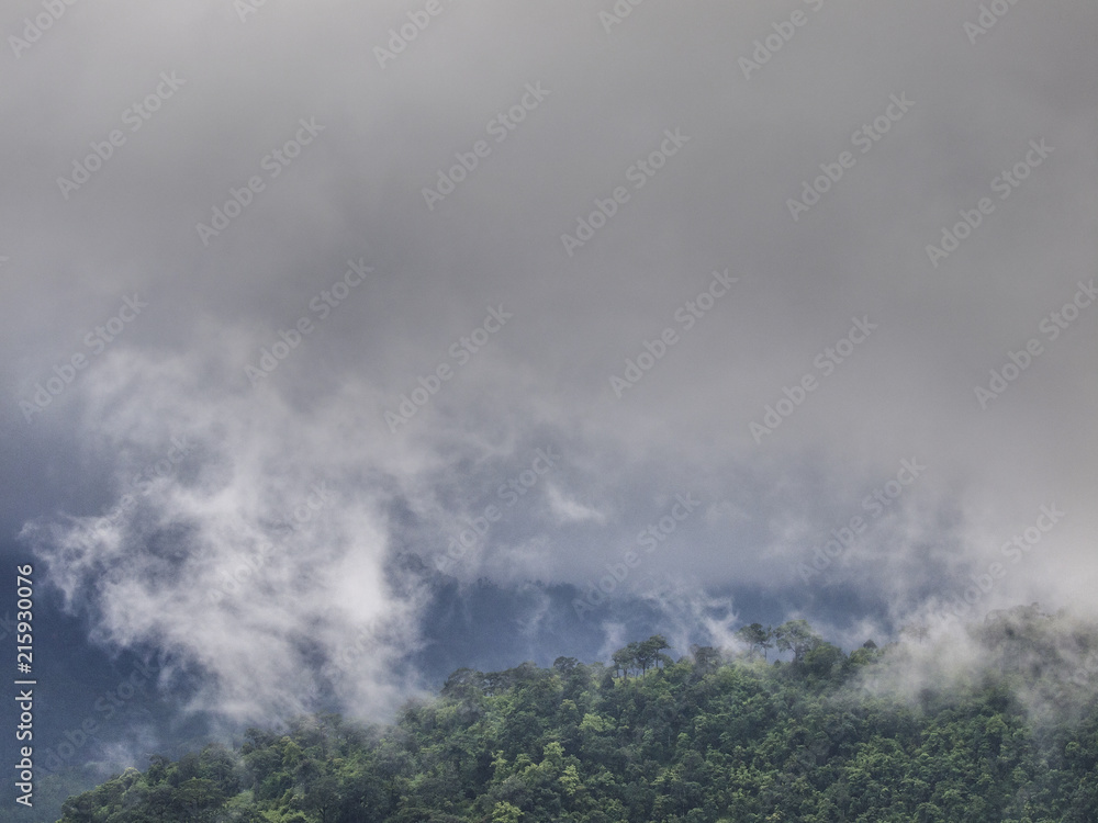 Wild monsoon clouds cover forested mountainous slopes in Kanchanaburi Province, eastern Thailand