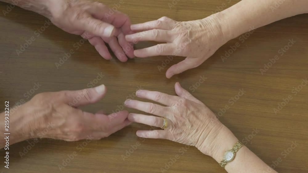 Top view of a romantic senior Caucasian couple holding hands across a table themes of romance retirement comfort marriage Top view of a romantic senior Caucasian couple holding hands across a table themes of romance retirement comfort marriage
