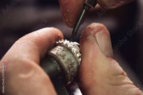 Close up of the hands of a goldsmith while he is making a diamond ring. Concept: jewelry, gold, fashion photo