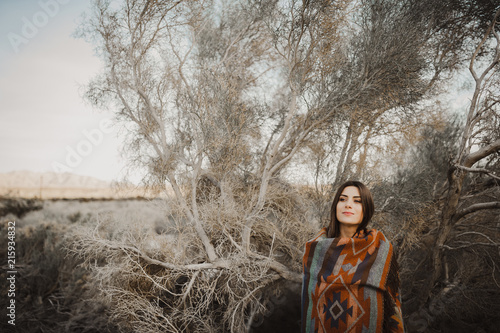 Hipster traveler girl in gypsy look in desert nature.  Artistic photo of young hipster traveler girl in gypsy look, in Coachella Valley in a desert valley in Southern California.