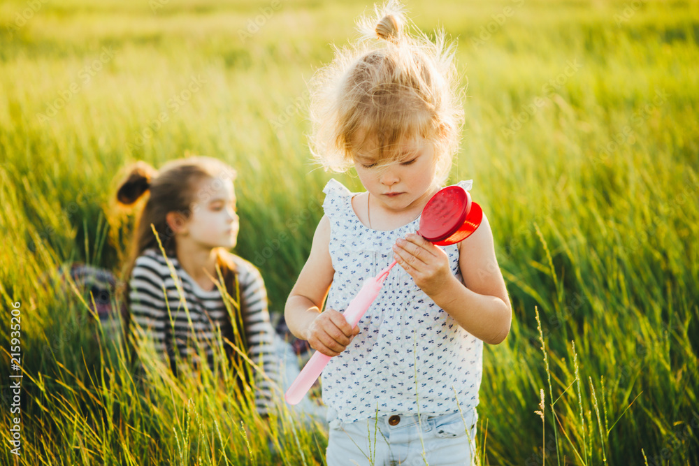 Cute little girl is blowing a soap bubbles Cute little girl is blowing a soap bubbles