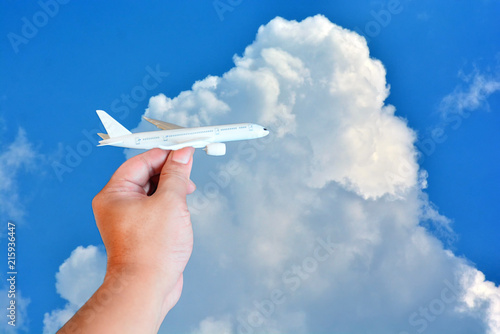 toy airplane in hand on beautiful sky with cloud background in concept travel around the world