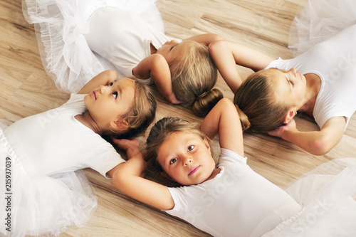 Top view of four dancers lying on the parquet floor of a dance school, who rest after exercising. Concept of: team, teaching, ambition, relaxation.