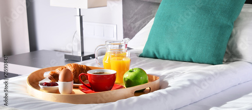 Breakfast on tray in bed in hotel room