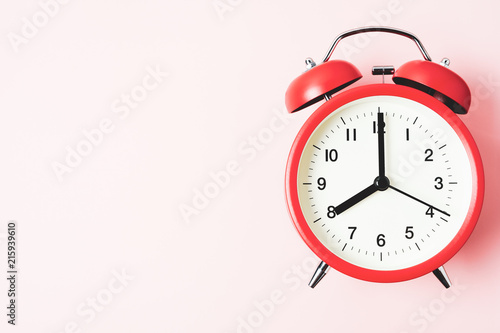 Red vintage alarm Clock show 8 O'Clock with copy space on pink background