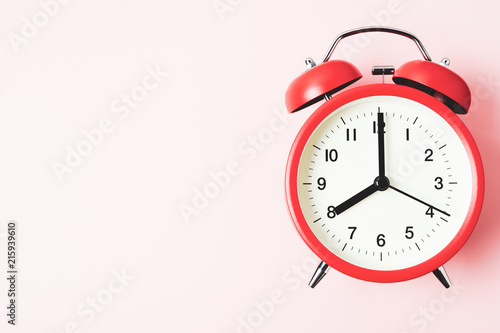 Red vintage alarm Clock show 8 O'Clock with copy space on pink background photo