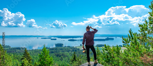 Ein Mann schaut auf der Spitze des Berges auf den See Dellen photo