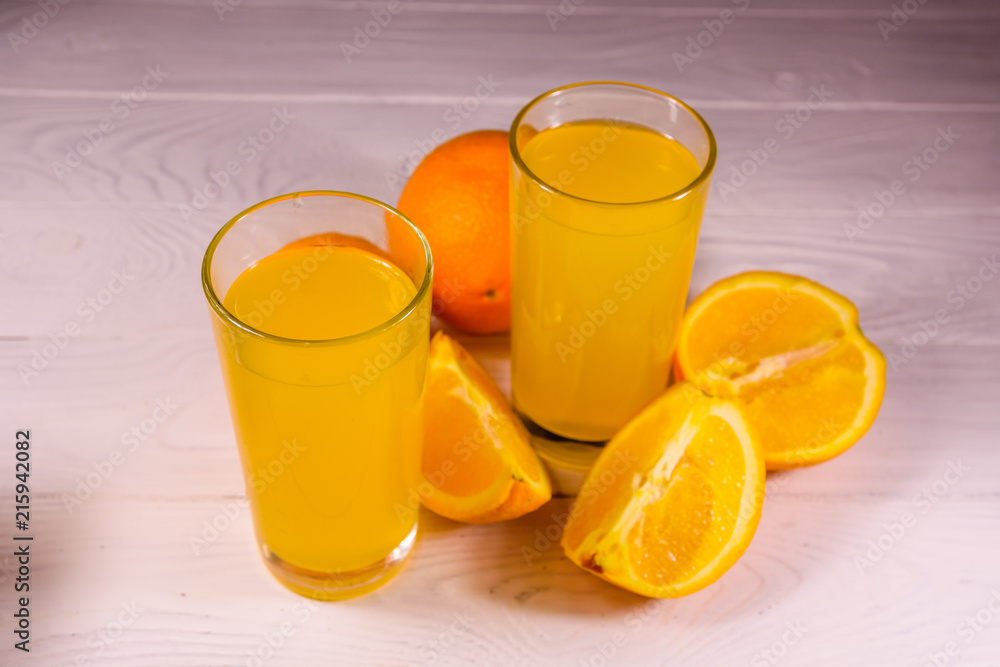 Oranges and glasses with orange juice on a wooden table Oranges and glasses with orange juice on a wooden table