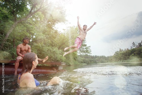 Enjoying river party with friends. Group of beautiful happy young people at the river together photo