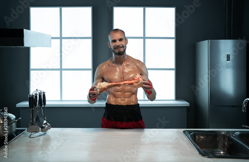 An athlete is eating meat with a large bone
